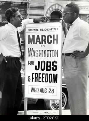 Bayard Rustin, Stellvertretender Direktor, Council for United Civil Rights Leadership, Cleveland Robinson, Vorsitzender des Verwaltungsausschusses, mit Schild zur Ankündigung des Marsches auf Washington für Jobs und Freiheit, vor dem Hauptquartier des rates, New York City, New York, USA, Orlando Fernandez, New York World-Telegram and the Sun Newspaper Photograph Collection, 7. August 1963 Stockfoto