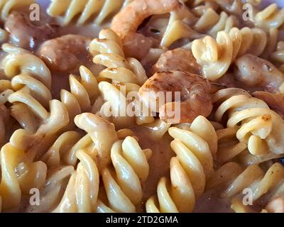 Köstliches Fusilli-Pastagericht in cremiger Sauce mit Meeresfrüchten wie Garnelen und Tintenfischen Stockfoto