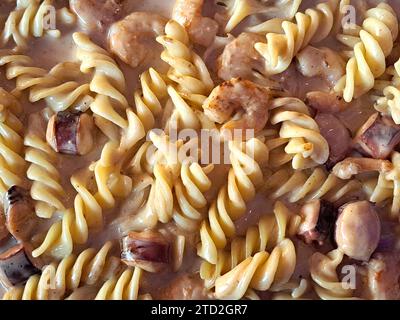 Köstliches Fusilli-Pastagericht in cremiger Sauce mit Meeresfrüchten wie Garnelen und Tintenfischen Stockfoto