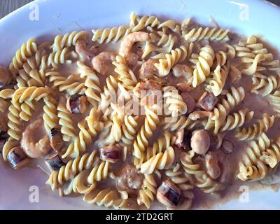 Köstliches Fusilli-Pastagericht in cremiger Sauce mit Meeresfrüchten wie Garnelen und Tintenfischen Stockfoto