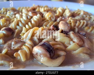 Köstliches Fusilli-Pastagericht in cremiger Sauce mit Meeresfrüchten wie Garnelen und Tintenfischen Stockfoto