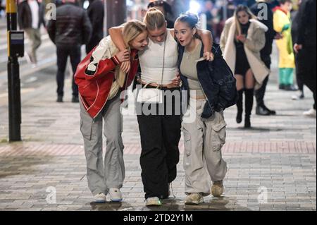 Broad Street, Birmingham 16. Dezember 2023 - die Nachtschwärmer haben am Freitag, den 15. Dezember Abend in Birmingham den berüchtigten Nachtclub-Strip besucht, als sie den vorletzten Freitag vor Weihnachten genossen. Mehrere Partygäste trugen Weihnachtsoutfits und eine Arbeitsfeier voller Santas, die für ein Gruppenfoto posierten, bevor sie sich auf den Weg zu einem anderen Pub machten. Freunde trugen einander entlang des Nachtlebens der Broad Street, als der Abend in den Morgen verwandelte. Andere wurden in Smart Wear gesehen, nachdem sie festliche Galas im Stadtzentrum besucht hatten. Viele Leute zeigten ihre Weihnachtspullover, während sie milde Temperaturen genossen. Die Stockfoto