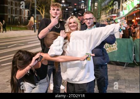 Broad Street, Birmingham 16. Dezember 2023 - diese Mädchen versuchen, Dabbing zurückzuholen, während sie für ein Foto posieren. - Nachtschwärmer besuchten am Freitag, den 15. Dezember Abend in Birmingham den berüchtigten Nachtclub, da sie den vorletzten Freitag vor Weihnachten genossen. Mehrere Partygäste trugen Weihnachtsoutfits und eine Arbeitsfeier voller Santas, die für ein Gruppenfoto posierten, bevor sie sich auf den Weg zu einem anderen Pub machten. Freunde trugen einander entlang des Nachtlebens der Broad Street, als der Abend in den Morgen verwandelte. Andere wurden in Smart Wear gesehen, nachdem sie festliche Galas im Stadtzentrum besucht hatten. Jede Menge Peop Stockfoto