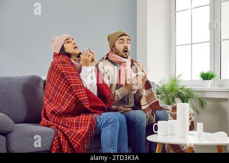 Kranke Paare mit Decken bedeckt, die an Erkältung und Grippe zu Hause leiden Stockfoto