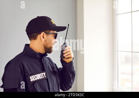 Männlicher Sicherheitswächter mit tragbarem Funksender im Innenbereich Stockfoto