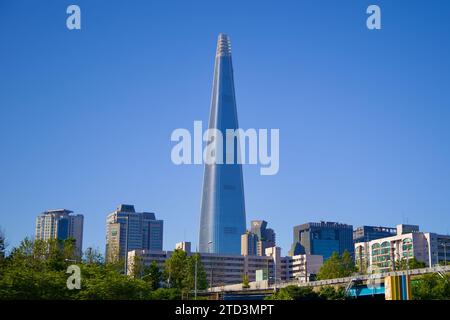 Seoul, Südkorea - 2. Juni 2023: Der Lotte World Tower thront über den kleinen Gebäuden des Songpa District, vor einem klaren blauen Himmel mit seinem ta Stockfoto