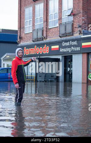 Kidderminster, Großbritannien. Dezember 2023. Eine große Überschwemmung als geplatzte Wasserleitung lässt eine Stadt in den Midlands ohne Wasser zurück. Eine 24-Zoll-Wasserleitung platzte in den frühen Morgenstunden, während sich Unternehmen auf ein geschäftiges Weihnachtswochenende vorbereiten. Einige Unternehmen können heute nicht eröffnet werden, während einige Bewohner in Wohnungen über den Grundstücken eingeschlossen werden, bis das Hochwasser abklingt. Quelle: Lee Hudson/Alamy Live News Stockfoto