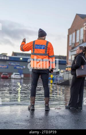 Kidderminster, Großbritannien. Dezember 2023. Eine große Überschwemmung als geplatzte Wasserleitung lässt eine Stadt in den Midlands ohne Wasser zurück. Eine 24-Zoll-Wasserleitung platzte in den frühen Morgenstunden, während sich Unternehmen auf ein geschäftiges Weihnachtswochenende vorbereiten. Einige Unternehmen können heute nicht eröffnet werden, während einige Bewohner in Wohnungen über den Grundstücken eingeschlossen werden, bis das Hochwasser abklingt. Quelle: Lee Hudson/Alamy Live News Stockfoto