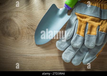 Handspaten-Sicherheitshandschuhe für Gartenarbeit auf Holzbrett Stockfoto