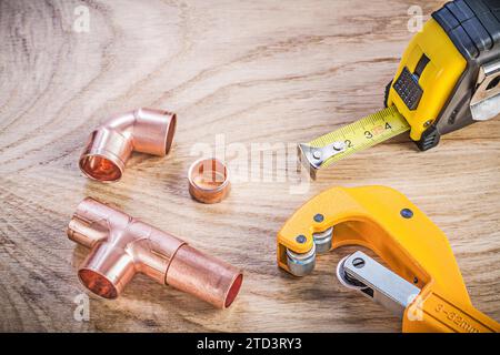 Zusammensetzung der Messing-Rohrschneider-Fittings Maßband auf Holzbrett-Sanitär-Konzept Stockfoto