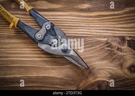 Scharfe Blechschere auf Vintage-Holzbrett mit Draufsicht Stockfoto