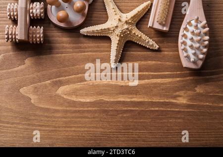 Holzmassagegeräte mit Seesternen und Nagelbürste auf klassischer Pinienboardsauna Stockfoto
