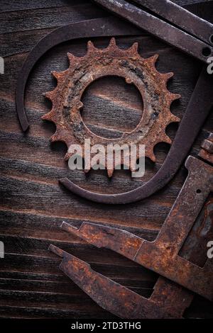 Vertikale Version des rostigen Bremssattels mit Zahnrad auf Vintage-Holzbrett-Konstruktionskonzept Stockfoto