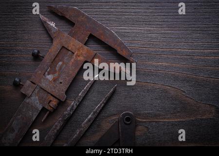 Rostiger Messschieber auf einem alten Holzbrett Stockfoto