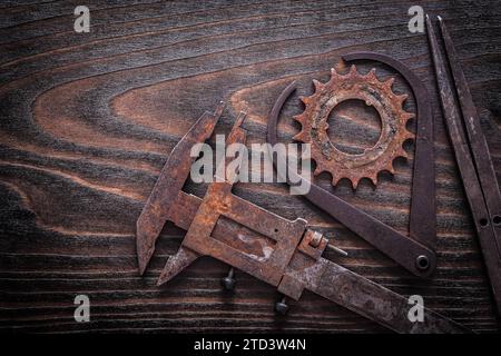 Horizontale Ausführung eines rostigen Bremssattels mit Zahnrad auf dunkler Holzoberfläche Stockfoto