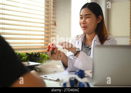 Asiatische Ernährungsberaterin in in der Gewichtsreduktion-Klinik. Ernährungs- und Ernährungskonzept Stockfoto