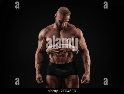 Perfekter Bauch. Weibliche Hände umarmen, berühren muskulöse Männer abs isoliert auf schwarzem Hintergrund. Sport, Workout, Bodybuilding-Konzept. Vorderansicht. Stockfoto