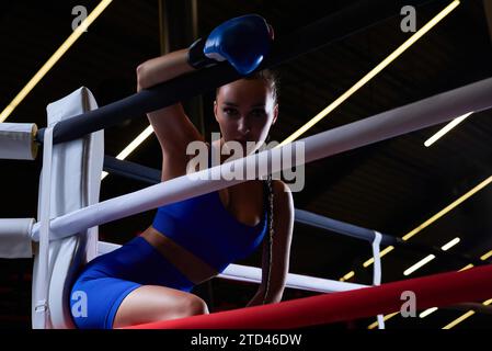 Schöne und starke Sportlerin posiert in der Ecke des Rings. Das Konzept von Wrestling und Boxen. Gemischte Medien Stockfoto