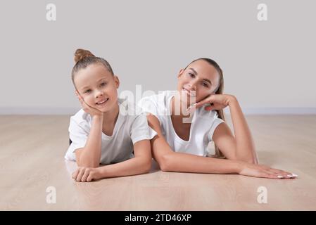 Schöne Lehrerin posiert mit einem kleinen Mädchen in einem Gymnastikkurs. Das Konzept der Bildung, Sport, Pilates, Stretching, gesunde Lebensweise. Stockfoto