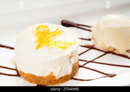 Sehr elegantes Zitronenmousse-Dessert, serviert mit Zitronenschale und Vanilleeis, KÖSTLICHERES ESSEN IM PORTFOLIO, Lebensmittelfotografie Stockfoto