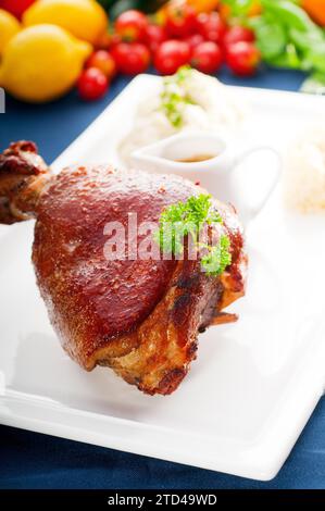 Original German BBQ Schweinshaxe serviert mit Kartoffelpüree und Sauerkraut, frisches Gemüse im Hintergrund, LECKERES ESSEN IM PORTFOLIO, Essen Stockfoto