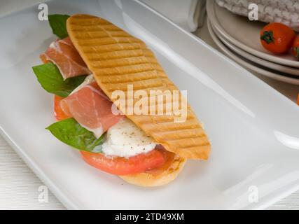 Panini-Sandwich mit frischer Caprese und parmaschinken, Lebensmittelfotografie Stockfoto