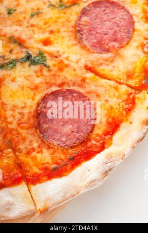 Italienische Original Pepperoni Pizza mit dünner Kruste extrene Nahaufnahme, Lebensmittelfotografie Stockfoto