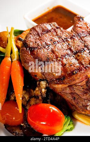 Frisch gegrilltes Ribeye-Steak mit Brokkoli, Karotten und Kirschtomaten auf der Seite, Lebensmittelfotografie Stockfoto