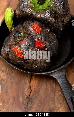 Drei frische Paprikaschoten, die auf einem alten Holztisch verbrannt sind, Lebensmittelfotografie Stockfoto