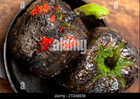 Drei frische Paprikaschoten, die auf einem alten Holztisch verbrannt sind, Lebensmittelfotografie Stockfoto