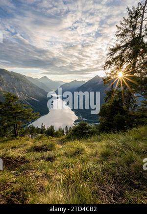 Blick auf den Plansee von Schoenjoechl bei Sonnenuntergang, Sonnenstern, Berge mit See, Gipfel des Thaneller im Hintergrund, Ammergauer Alpen, Reutte Stockfoto