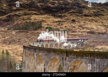 Der Jakobitenzug fährt über den Glenfinnan Viaduct, Highlands, Schottland. Berühmt durch die Harry-Potter-Filme. Stockfoto