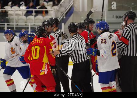 Dumfries, 11. Dezember 2023. Die Linespersonals Doyeon Choi und Daniel Rigoni trennten die Spieler aus China und Spanien während des Nahkampfes vor dem Tor während einer IIHF Eishockey U20 Weltmeisterschaft 2024, Division II, Gruppe A im Dumfries Ice Bowl. Quelle: Colin Edwards Stockfoto