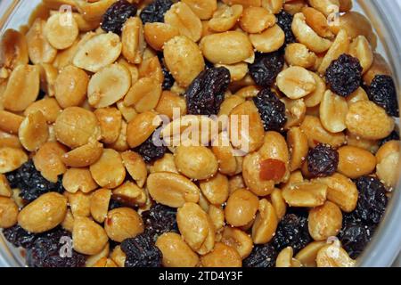 Nahaufnahme von knusprigen gerösteten Erdnüssen und glatten Rosinen in einer Schüssel, die als Snack auf einer Party oder einem Empfang gegessen werden kann; Stockfoto