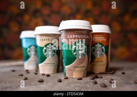 starbucks-Kaffee in Tassen im Sortiment auf dem Tisch mit Kaffeebohnen. Stockfoto