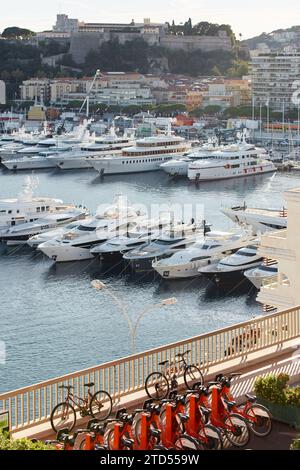 Monaco, Monte Carlo, 18. Oktober 2022: Sonnenuntergang Panorama von Port Hercule, vertäute Mega-Yacht, Sonnenspiegelung Stockfoto