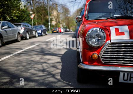 Lerner Fahrer L-Schild auf der Vorderseite eines alten roten Miniwagens, der auf einer Straße in Schottland, Großbritannien, geparkt ist Stockfoto