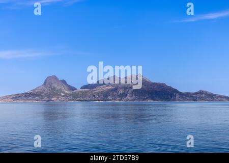 Ein malerischer Blick auf die Nordsee und einen zerklüfteten Berg, der über seinem ruhigen Wasser thront, von einer Fähre zur Insel Lofoten an einem sonnigen Sommertag gesehen Stockfoto