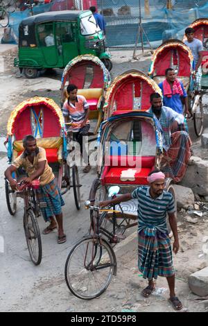 Dhaka, Oktober, 16, 2022überfüllt mit Rikschas, eine Straße im Zentrum von Dhaka, Rikscha-Puller, der Ruhe nimmt, Bangladesch, Südasien Stockfoto