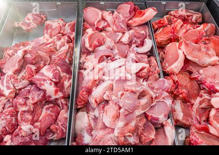 Verschiedene Stücke von Schweinefleisch Steaks, verschiedene Körperteile, die Fleisch zum Verkauf in Behältern an einer Ladentische schneiden Stockfoto