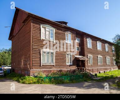 Murmansk, Russland - 09. August 2021: Zweistöckiges altes Blockhaus mit zwei Eingängen, Stadt Murmansk Stockfoto