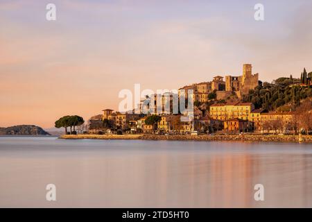 Das Dorf Passignano auf einem Hügel spiegelt sich im See Trasimeno in Umbrien, Italien Stockfoto