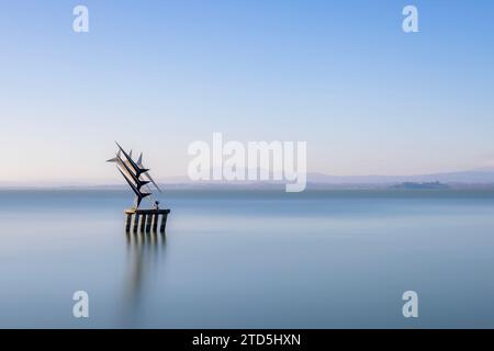 Das Dorf Passignano auf einem Hügel spiegelt sich im See Trasimeno in Umbrien, Italien Stockfoto