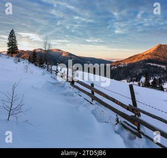 Sonnenaufgang morgen winter Mountain Village Stadtrand. Blick vom ländlichen schneebedeckten Pfad am Hang, Zelene, Verkhovyna Ukraine. Stockfoto