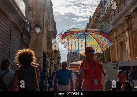 Ein farbenfroher Sonnenschirm zum Schutz vor der Hitze der Sonne in den Straßen von Valletta, oft voll mit Touristen Stockfoto