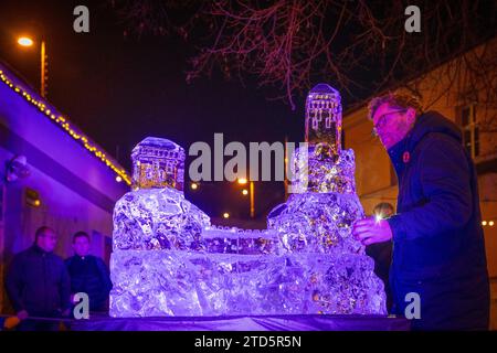 Liberec, Tschechische Republik. Dezember 2023. Die dritte jährliche Eisskulptur in Turnov am 16. Dezember 2023. Der Bildhauer schnitzte und schuf mit Hilfe einer Säge und Meißeln eine Statue eines der dominanten Merkmale des Böhmischen Paradieses - Trosky Castle - aus mehr als einer Tonne Eis an einem Tag. Wie lange es auf dem Hof dauert, hängt vom Wetter ab. Quelle: Radek Petrasek/CTK Photo/Alamy Live News Stockfoto