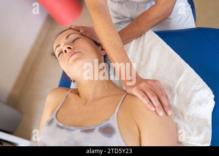 Physiotherapeut, der den Hals des Klienten in der Klinik dehnt Stockfoto