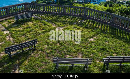 Bänke, die Schatten auf dem Balkon der Statue werfen: Christus der Barmherzigkeit. Balkonbarriere aus bewachsenem Gras aus Beton. San Juan del Sur, Nicaragua Stockfoto