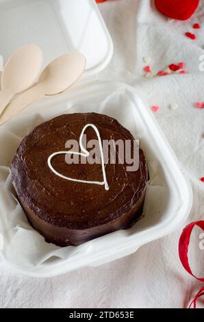 Kleiner, trendiger bento-Kuchen. Schokoladenkuchen mit weißem Herz. Kuchen zum Valentinstag, Muttertag oder Geburtstag, Love Forever Message, Romanti Stockfoto