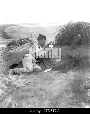 07/31/1909. Foto Alba. Szenen aus dem Camp. Die ständige Kommunikation per Post mit der Familie und der Braut ist das, was die Ermüdung des Feldzuges für den spanischen Soldaten am meisten versüßt. Papier und Bleistift sind wichtige Dinge, und was einen Schreibtisch betrifft, so ist alles gut: Eine Schachtel Munition, ein Rucksack, ein Lagerfelsen, alles dient als Stütze, auf der sie die kurzen Linien zeichnen, die man meistens anfängt: 'Liebe Eltern. Quelle: Album / Archivo ABC / Ramón Alba Stockfoto